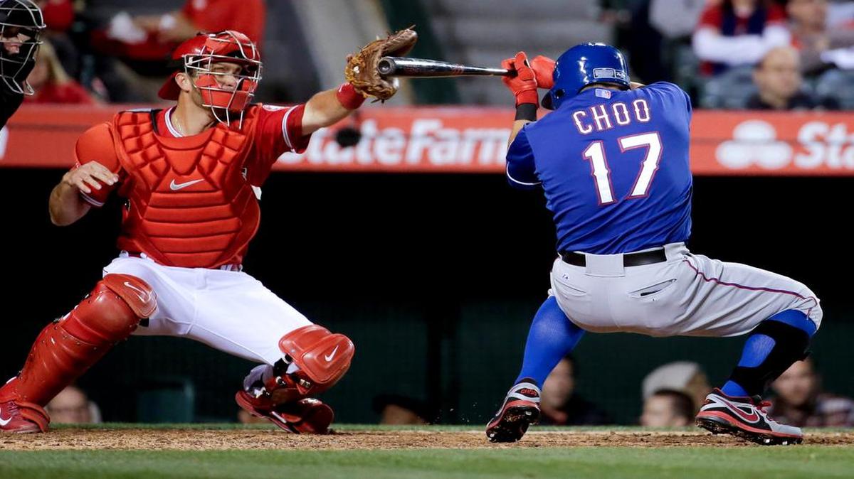 
The Rangers' Shin-Soo Choo gets out of the way of a pitch as Angels catcher Drew Butera catches the ball during an April 15 baseball game in Anaheim, Calif.
