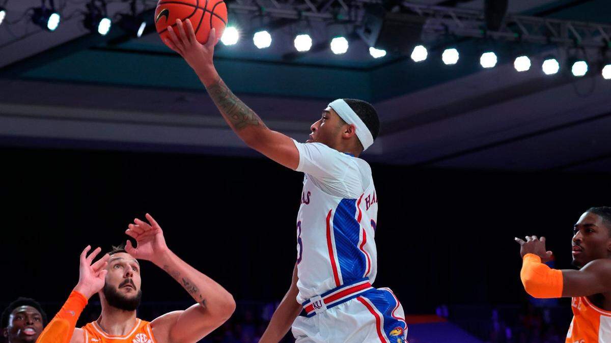 In a photo provided by Bahamas Visual Services, Kansas’ Dajuan Harris shoots next to Tennessee’s Uros Plavsic during the Battle 4 Atlantis at Paradise Island, Bahamas, on Nov. 25, 2022.