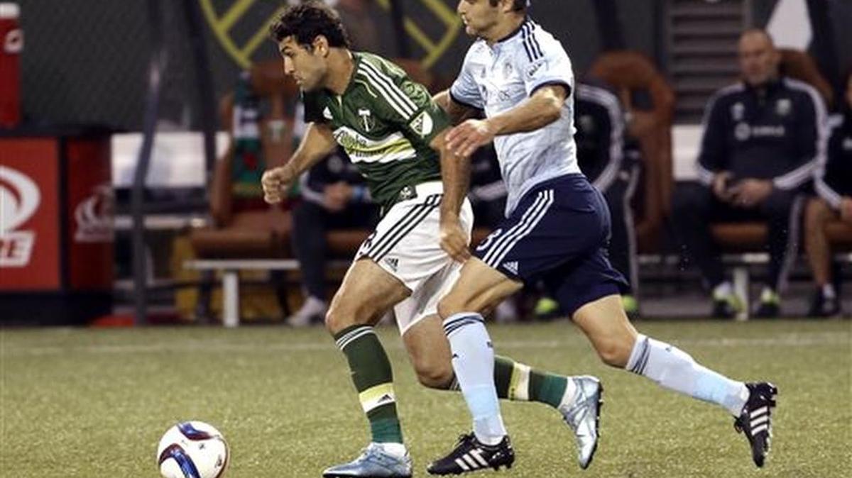 
Sporting Kansas City midfielder Graham Zusi, right, chases down the ball against Portland Timbers midfielder Diego Valeri during the first half of an MLS soccer match in Portland, Ore., Wednesday, Sept. 9, 2015. (AP Photo/Don Ryan)
