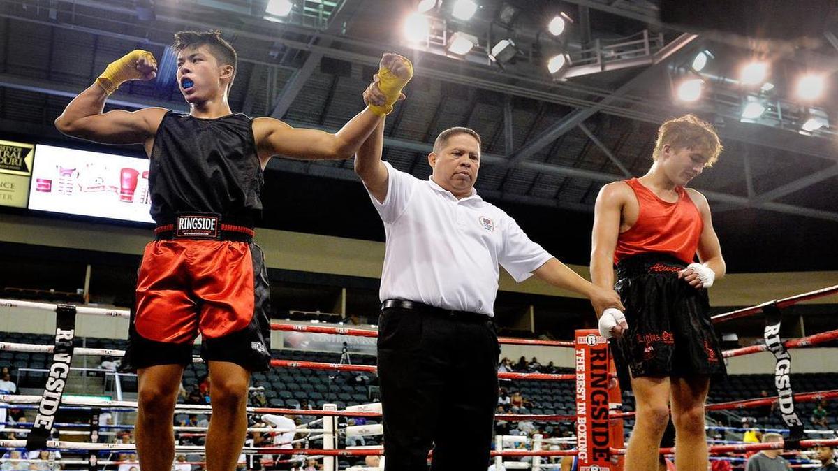 
The Ringside World Championships holds its 15th annual amateur boxing championship tournament at the Independence Events Center through Saturday. More than 1,000 bouts take place on six rings for boxers 8 years old and older. Eric Priest of Olathe (left) reacts Thursday as referee Gabriel Alarcon indicates he is the winner in a men's youth novice bout for 17- to 18-year-olds against Ryan Atwood of Eureka, Mo.
