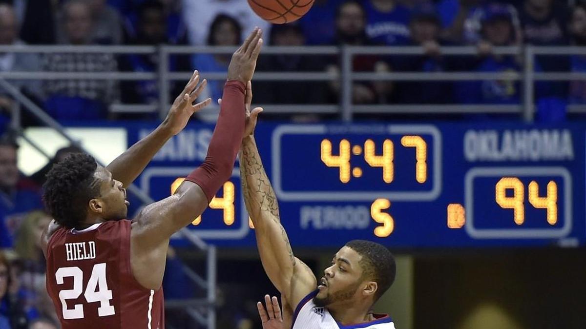 OU’s Buddy Hield lets go of a three-pointer over KU’s Frank Mason during the Jayhawks triple-overtime win at Allen Fieldhouse.