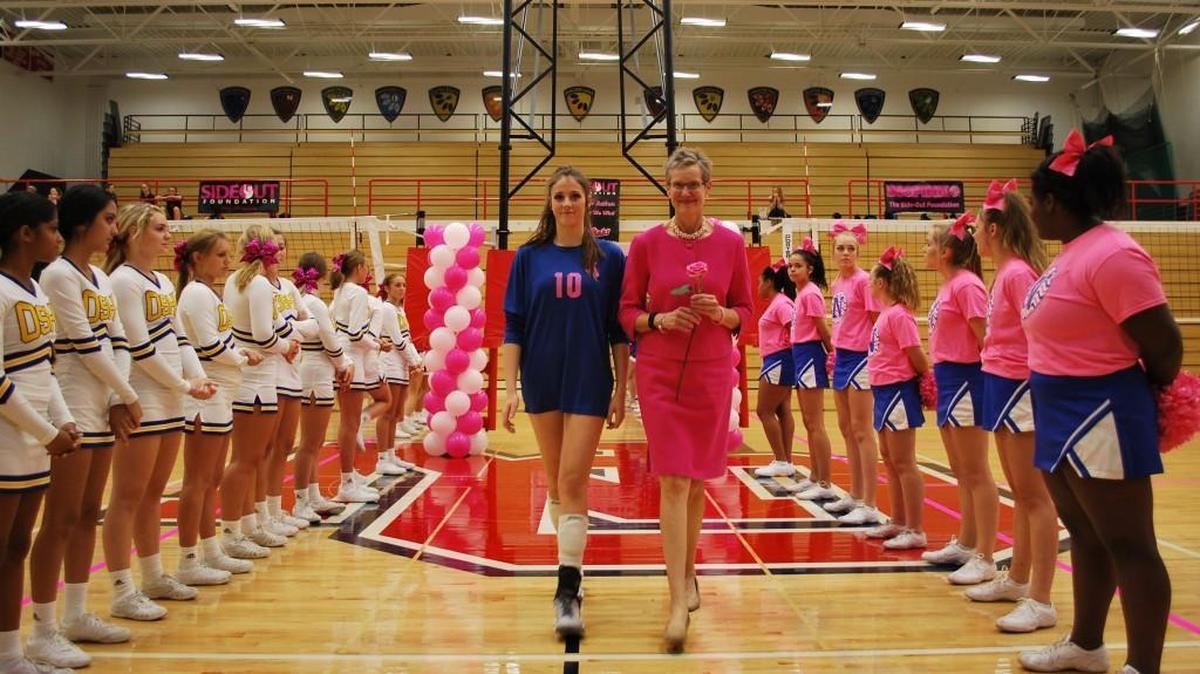 Breast cancer survivor Alison Banikowski, right, was escorted by Olathe Northwest junior Lindsey Heller at the fifth annual Olathe Dig Pink event, a fundraiser for the Side-Out Foundation, at Olathe South High in October. The non-profit foundation raises money for awareness and treatment of metastatic breast cancer.