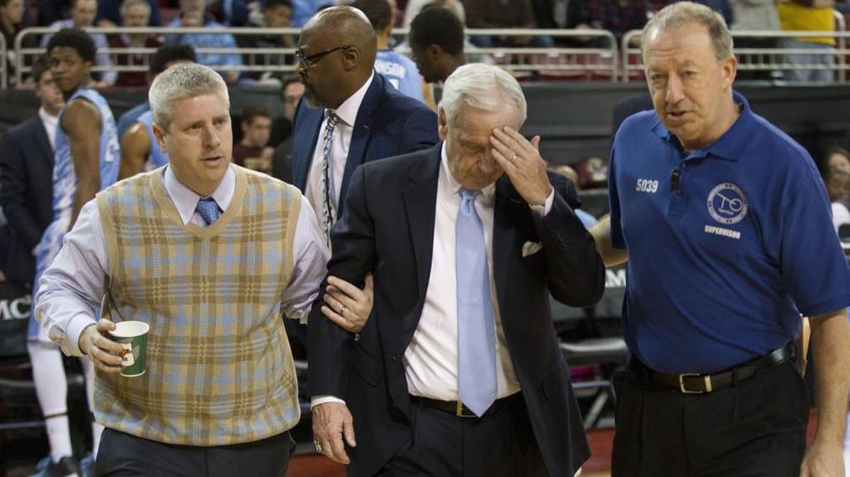 North Carolina head coach Roy Williams is escorted off the court by trainer Doug Halverson, left, and game staff early in the second half against Boston College Tuesday