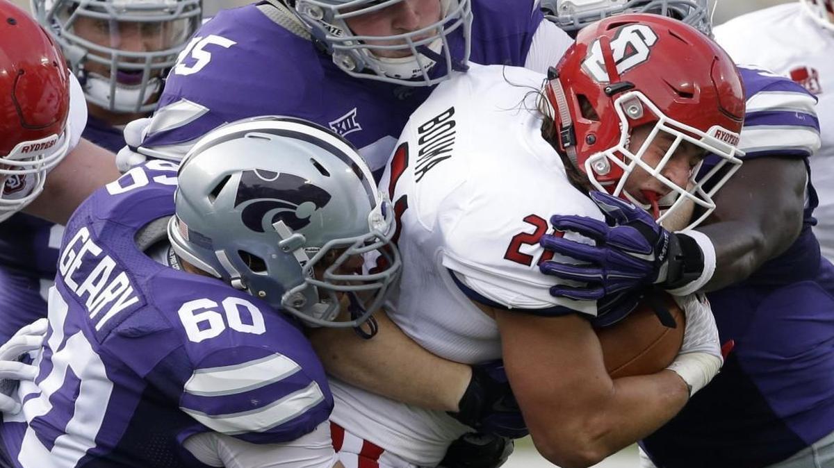 South Dakota running back Trevor Bouma was tackled by Kansas State defensive tackle Will Geary (bottom left) and other Wildcat defenders during a game in September.
