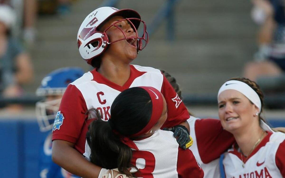 Oklahoma’s Kelsey Arnold, left, celebrates with teammates Melanie Olmos (18) and Macey Hatfield (6) after scoring in the second inning of the second game of the best-of-three championship series in the NCAA Women’s College World Series against Florida in Oklahoma City on Tuesday.