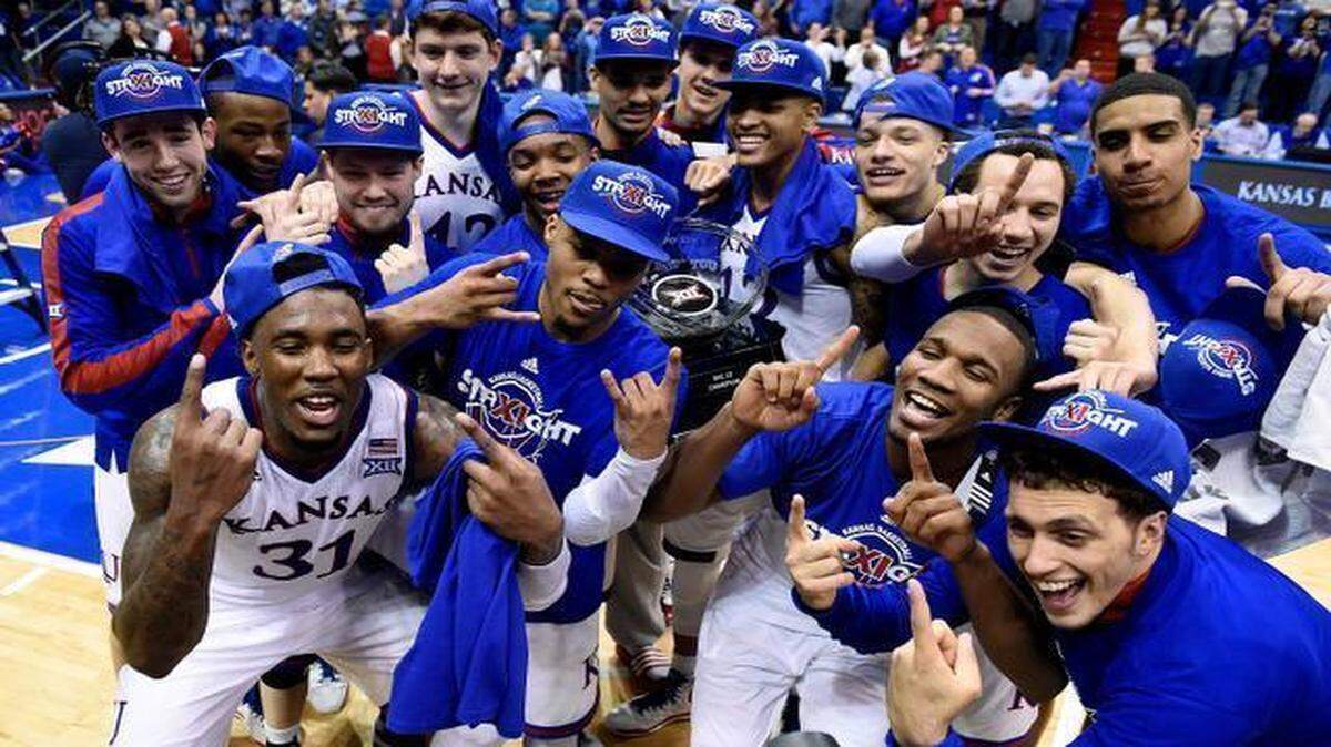 The Kansas Jayhawks celebrate winning their 11th straight Big 12 Conference title with a 76-69 overtime win over West Virginia at Allen Fieldhouse.
