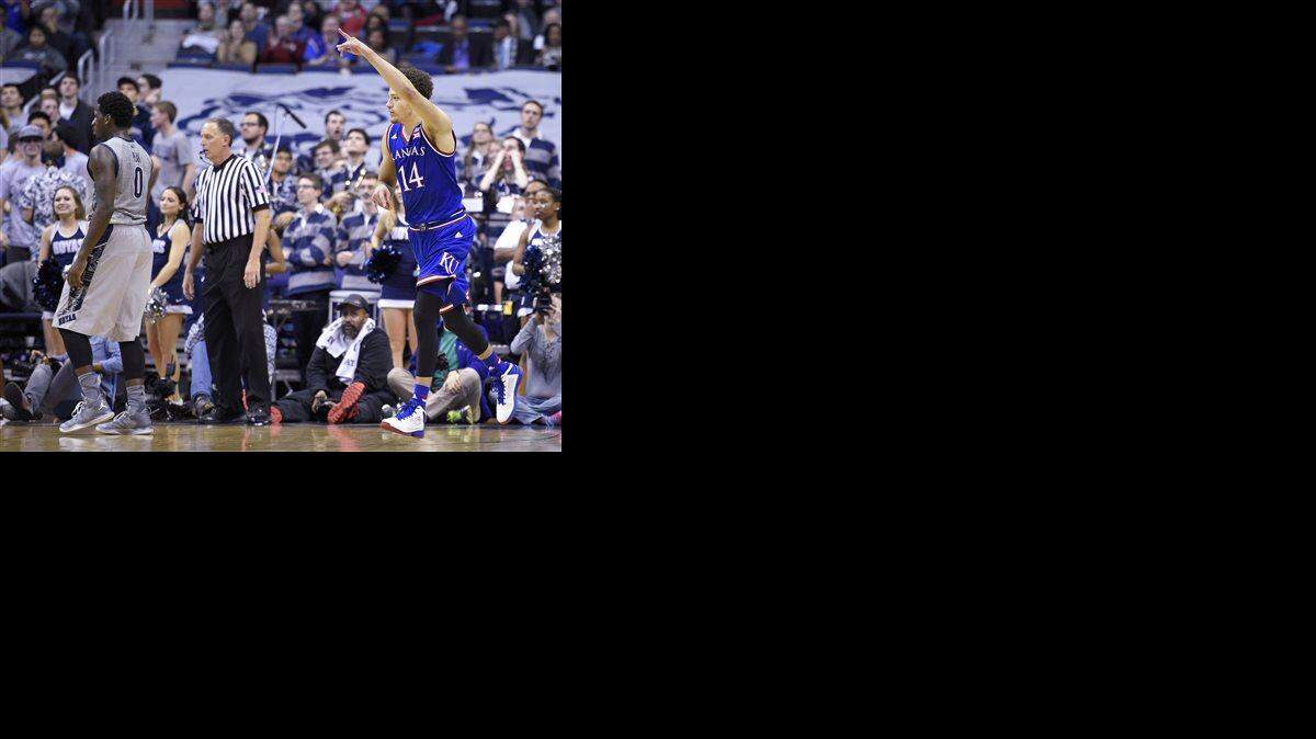 
Kansas' Brannen Greene (14) points after he hit a basket during the second half of an NCAA college basketball game as Georgetown's L.J. Peak (0) looks on at left, Wednesday, Dec. 10, 2014, in Washington. Kansas won 75-70. (AP Photo/Nick Wass)
