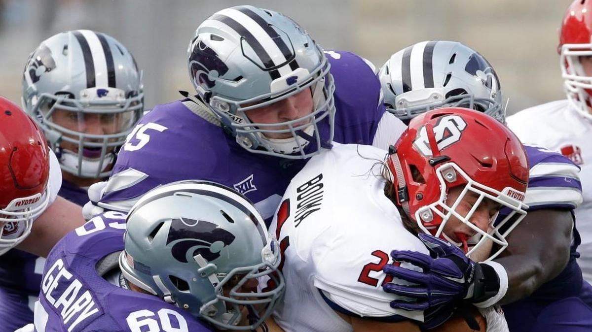 
South Dakota running back Trevor Bouma (21) ws tackled by Kansas State defensive tackles Will Geary (60), Travis Britz (95) and linebacker Elijah Lee in the first half Saturday night in Manhattan, Kan.
