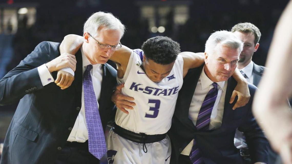 K-State guard Kamau Stokes is helped from the court by K-State head coach Bruce Weber (right) after injuring his knee Saturday during the Mississippi-K-State game. (January 30, 2016)