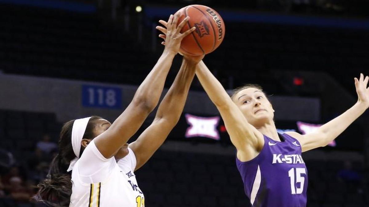 K-State’s Megan Deines (right) battled with West Virginia forward Teana Muldrow for the ball in the first half on Saturday night in the Big 12 tournament.