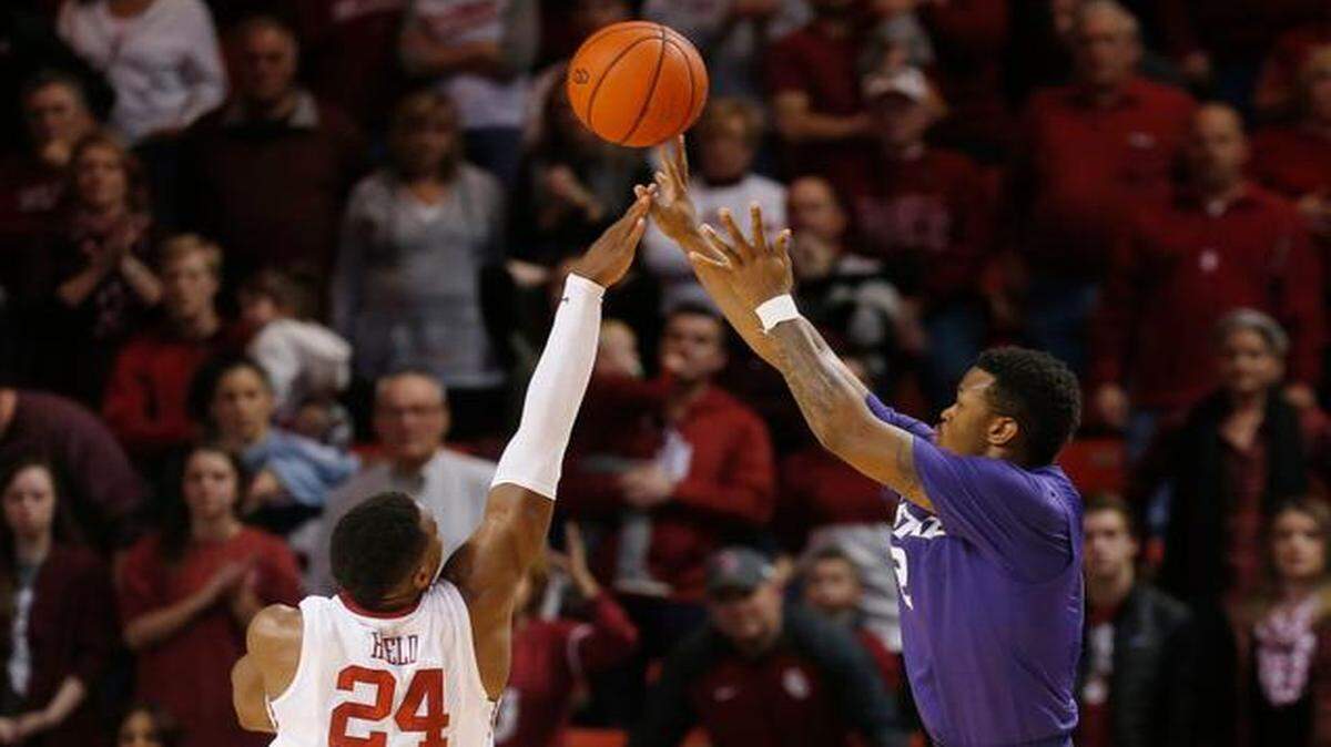 
Kansas State guard Marcus Foster, right, shoots a 3-pointer with 4 seconds left in the overtime for the game winner over Oklahoma guard Buddy Hield (24), in overtime of an NCAA college basketball game in Norman, Okla., Saturday. Kansas State won 66-63, in overtime. (AP Photo/Sue Ogrocki)
