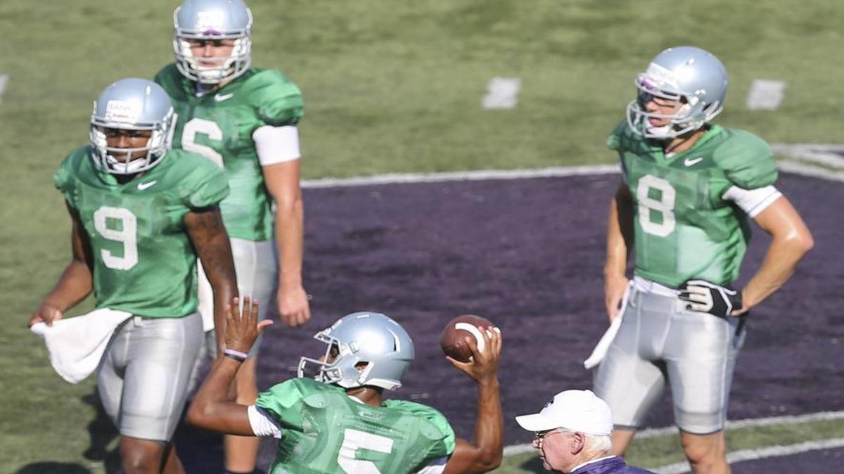 
Kansas State coach Bill Snyder watches freshman Alex Delton throw a pass while three other quarterback contenders wait their turns during the team's open practice Saturday at Snyder Family Stadium.
