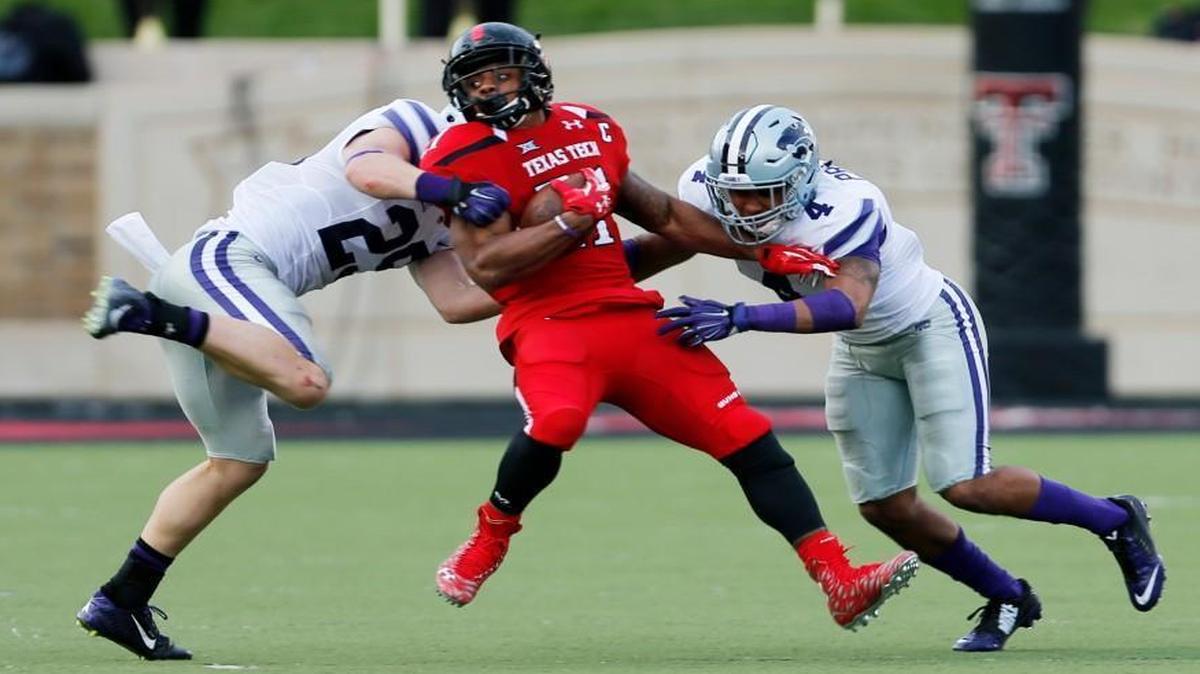 Texas Tech running back DeAndre Washington was tackled by Kansas State defensive back Kendall Adams and Duke Shelley during Saturday’s game.