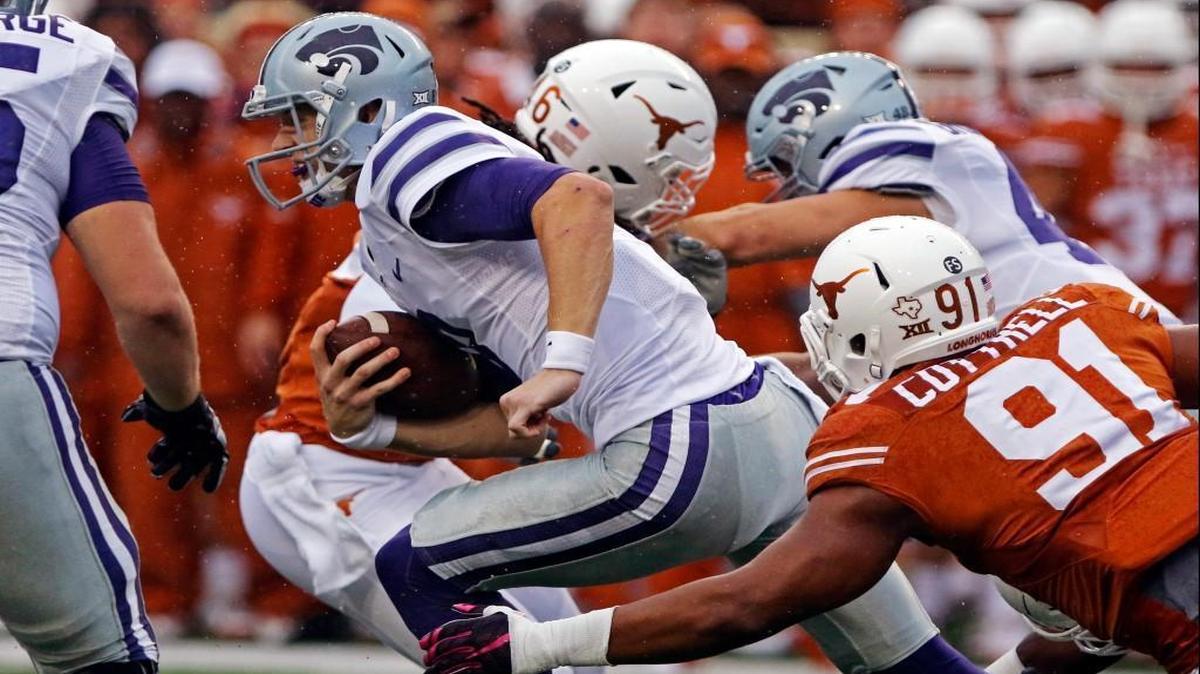 Kansas State quarterback Joe Hubener runs the ball against Texas lineman Bryce Cottrell (91) during the first half of Saturday’s Big 12 football game in Austin.