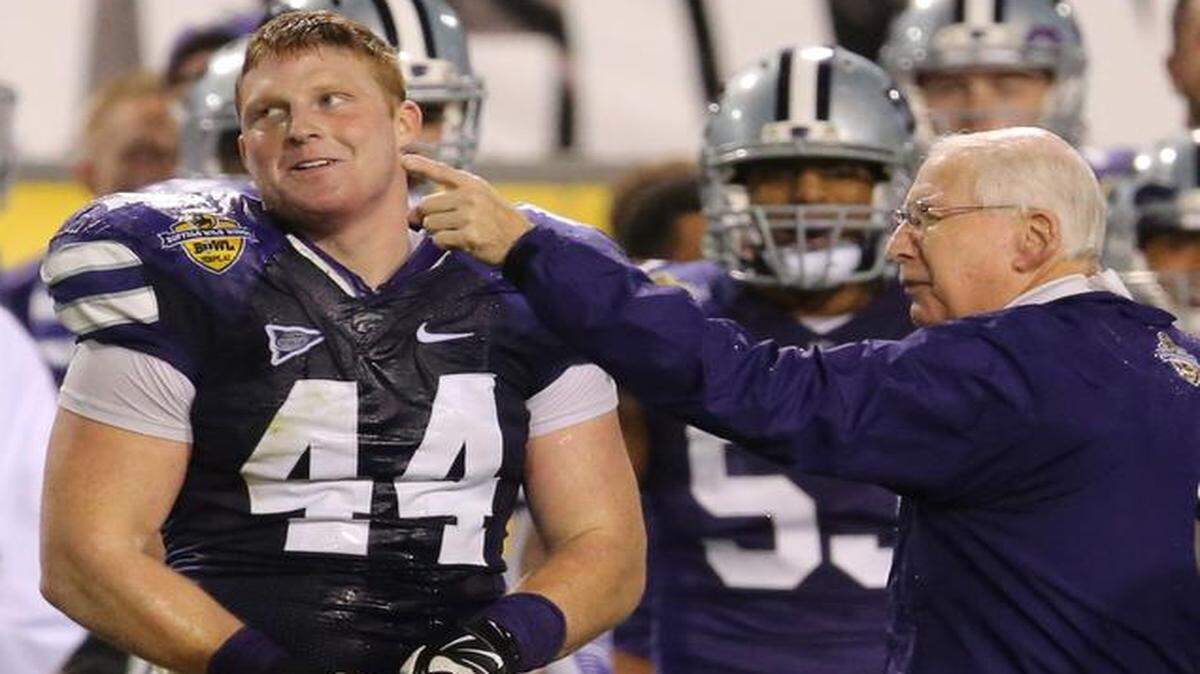 
K-State coach Bill Snyder points out the remaining time on the clock to defensive end Ryan Mueller (44) after Mueller dumped a jug of water onto Snyder near the end of the Buffalo Wild Wings Bowl. 
