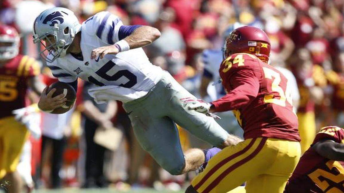 
K-State quarterback Jake Waters (15) jumps over Iowa State defensive back T.J. Mutcherson (22) as he makes a long run in the 4th quarter Saturday against Iowa State. (September 6, 2014)
