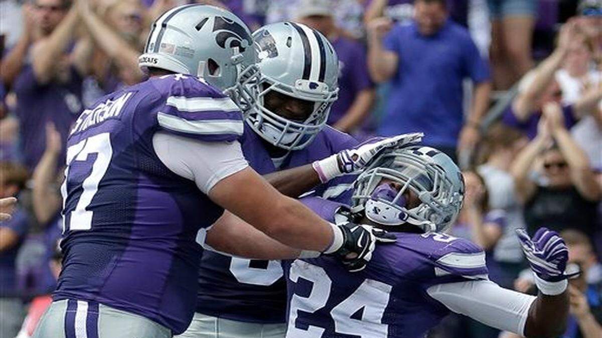 
Kansas State running back Charles Jones (24) celebrated with teammates Boston Stiverson (left) and Deante Burton after Jones scored a touchdown during Saturday’s college football game against UTEP in Manhattan
