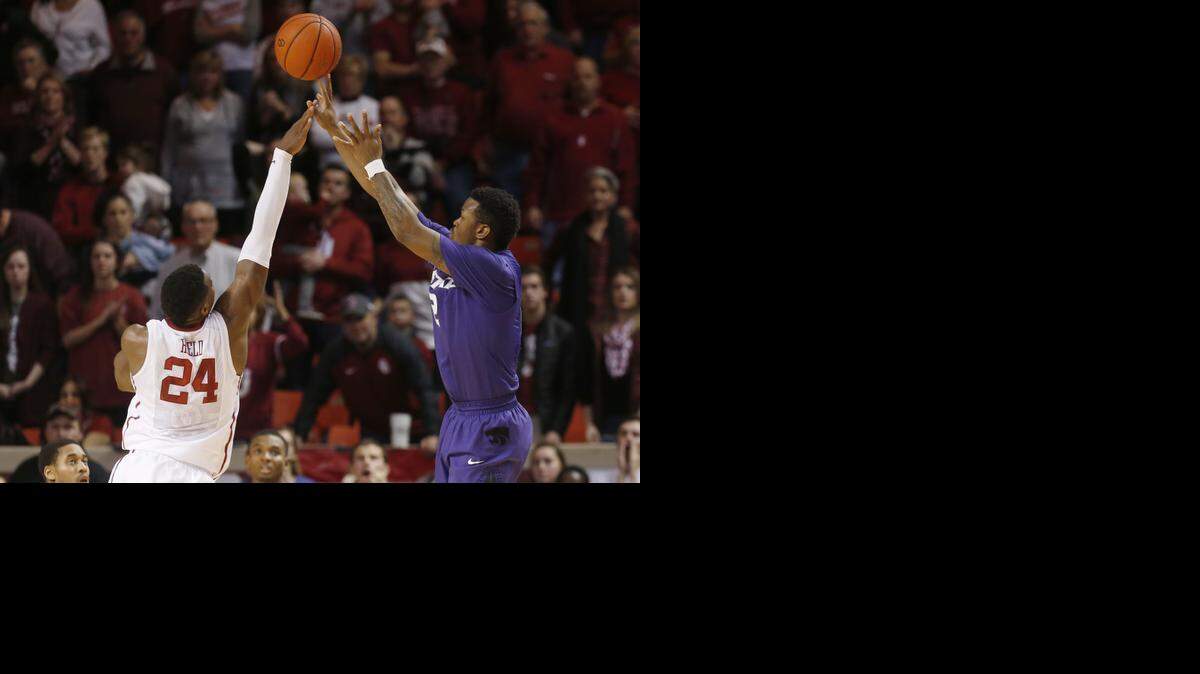 
Kansas State guard Marcus Foster, right, shoots a 3-pointer with 4 seconds left in the overtime for the game winner over Oklahoma guard Buddy Hield (24), in overtime of an NCAA college basketball game in Norman, Okla., Saturday, Jan. 10, 2015. Kansas State won 66-63, in overtime. (AP Photo/Sue Ogrocki)
