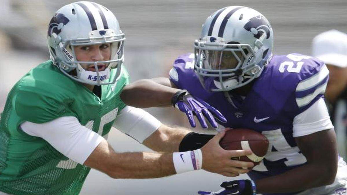 
Kansas State quarterback Jake Waters (left) handed the ball to Charles Jones the team’s spring scrimmage.
