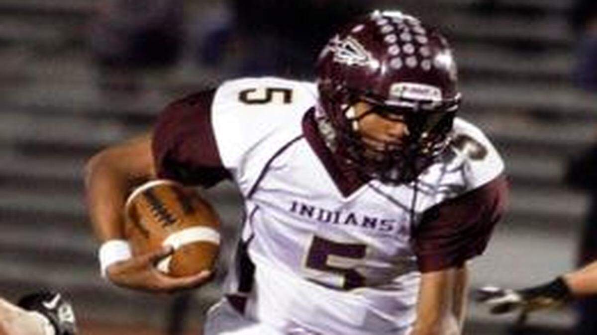 
Hays quarterback Alex Delton runs through a hole against Carroll.
