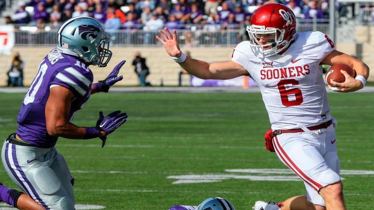 
Oklahoma quarterback Baker Mayfield (6) eluded Kansas State defensive backs Nate Jackson (bottom) and Donnie Starks in the first half Saturday in Manhattan, Kan.

