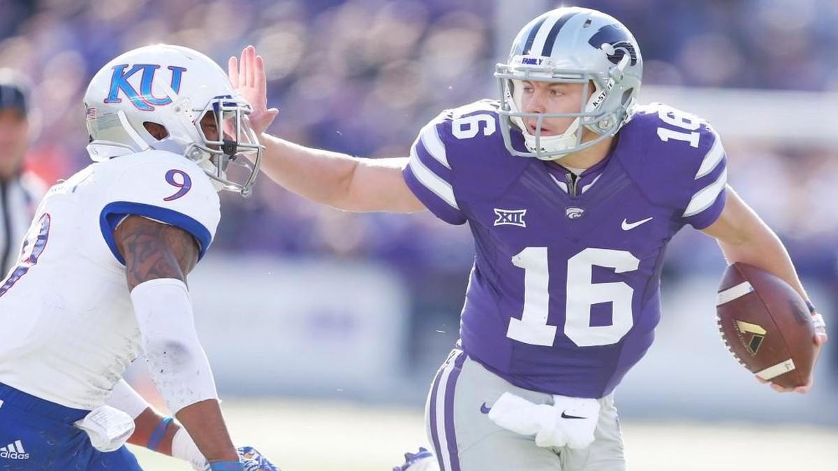 K-State quarterback Jesse Ertz pushes away Kansas safety Fish Smithson during a game in late November.