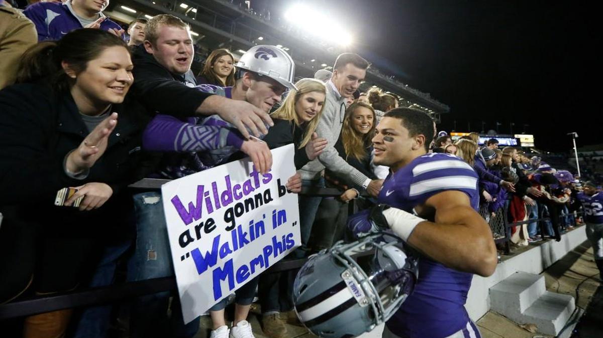 Kansas State defensive back Morgan Burns (33) celebrated with fans after the Wildcats defeated West Virginia 24-23 on Saturday in Manhattan, Kan. Burns had a 97-yard kickoff return. The fan’s sign proved correct, as the Wildcats are headed to the Liberty Bowl on Jan. 2 in Memphis, Tenn., where they will play Arkansas.