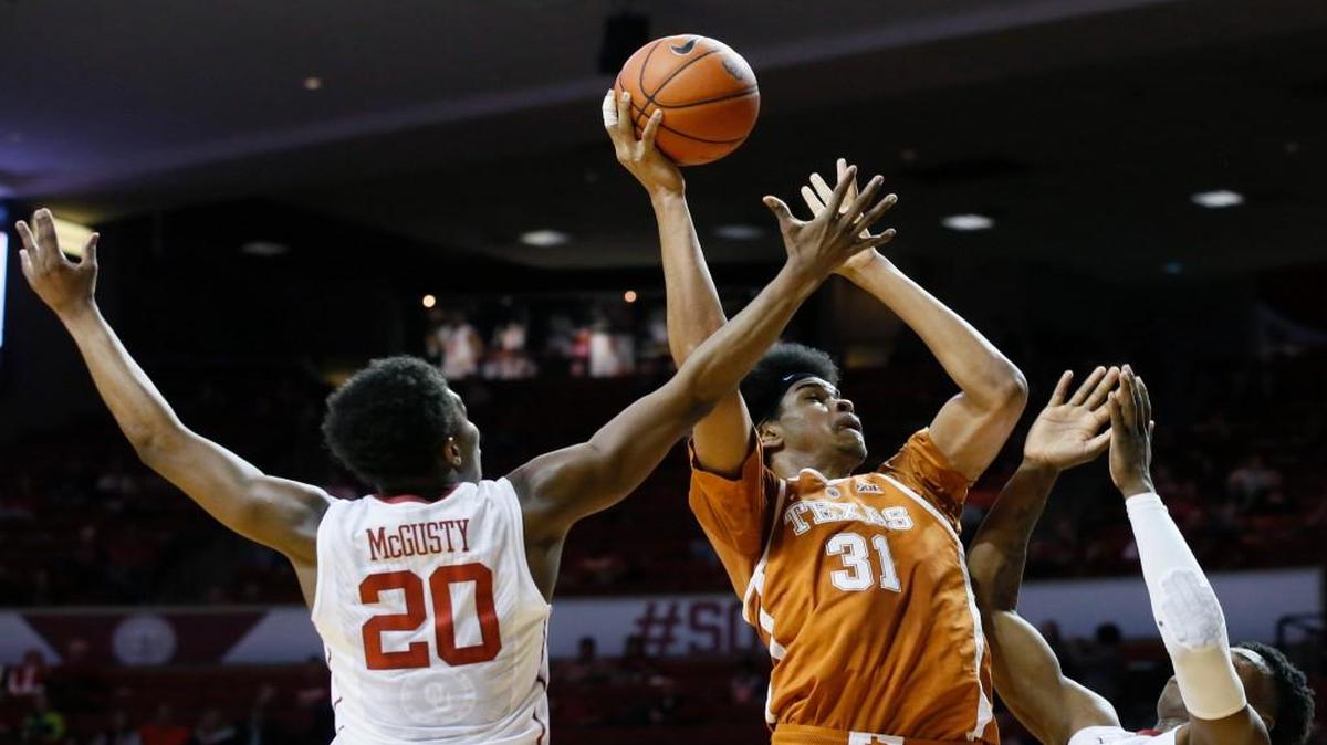 Texas forward Jarrett Allen (31) shoots between Oklahoma guard Kameron McGusty (20) and forward Kristian Doolittle (11) during the first half in Norman, Okla., on Feb. 14.