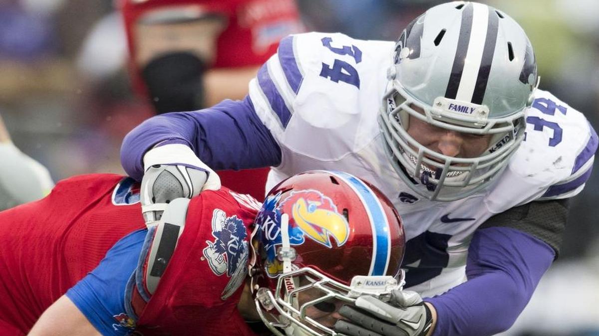 Kansas Jayhawks cornerback Derrick Neal was knocked to the ground by Kansas State Wildcats defensive end Tanner Wood during a game last November.