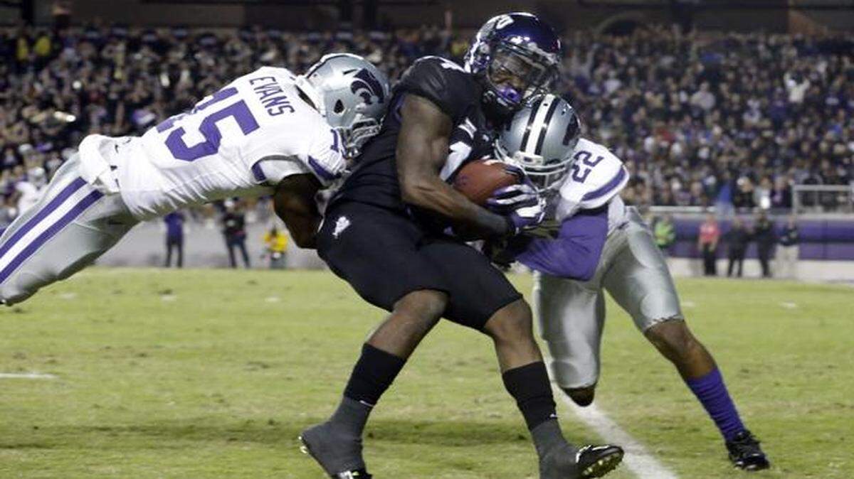 
TCU wide receiver David Porter, center, is tackled by Kansas State defensive backs Dante Barnett and Randall Evans. 
