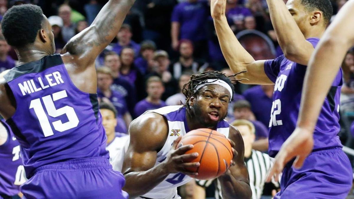 K-State forward D.J. Johnson looks for a route the basket as he battles with TCU defenders on Wednesday in Manhattan
