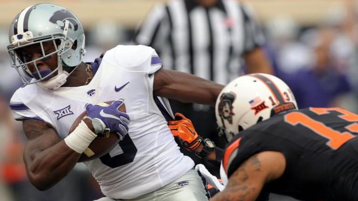 
Kansas State wide receiver Deante Burton (center) struggled to keep his feet while being tackled by Oklahoma State cornerback Michael Hunter (back) and safety Jordan Sterns in the first quarter Saturday in Stillwater, Okla.
