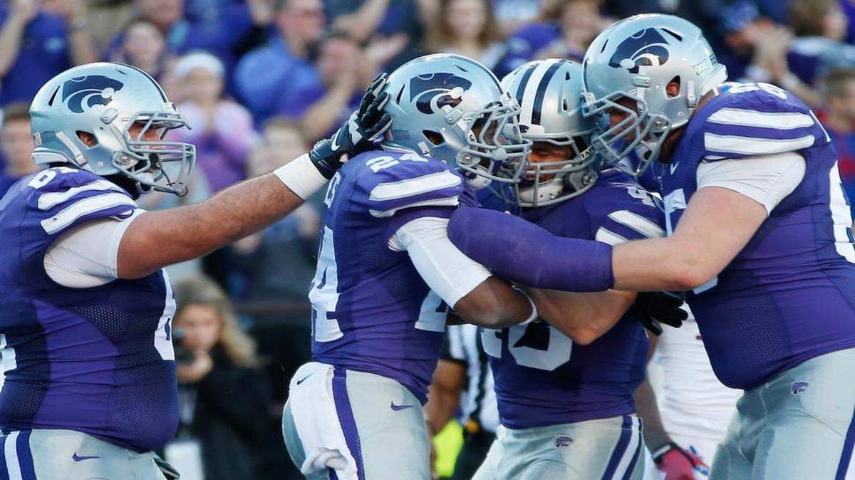 
K-State players celebrate withe running back Charles Jones after he scored a touchdown against Kansas last season.
