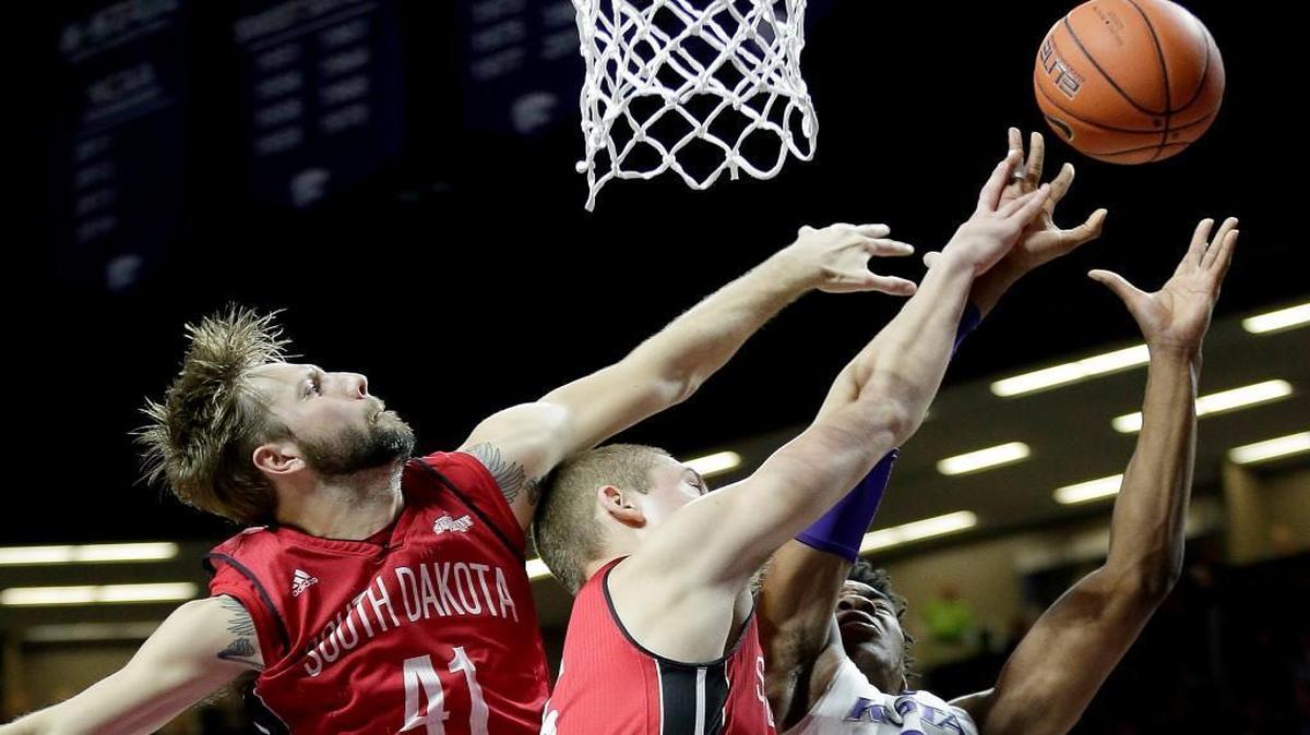 Wesley Iwundu (right) and the rest of the Wildcats faced pressure from South Dakota, including from Eric Robertson (left) and Tyler Hagedorn, on Friday in Manhattan, Kan. But Kansas State pulled ahead in the second half and held on for the win.