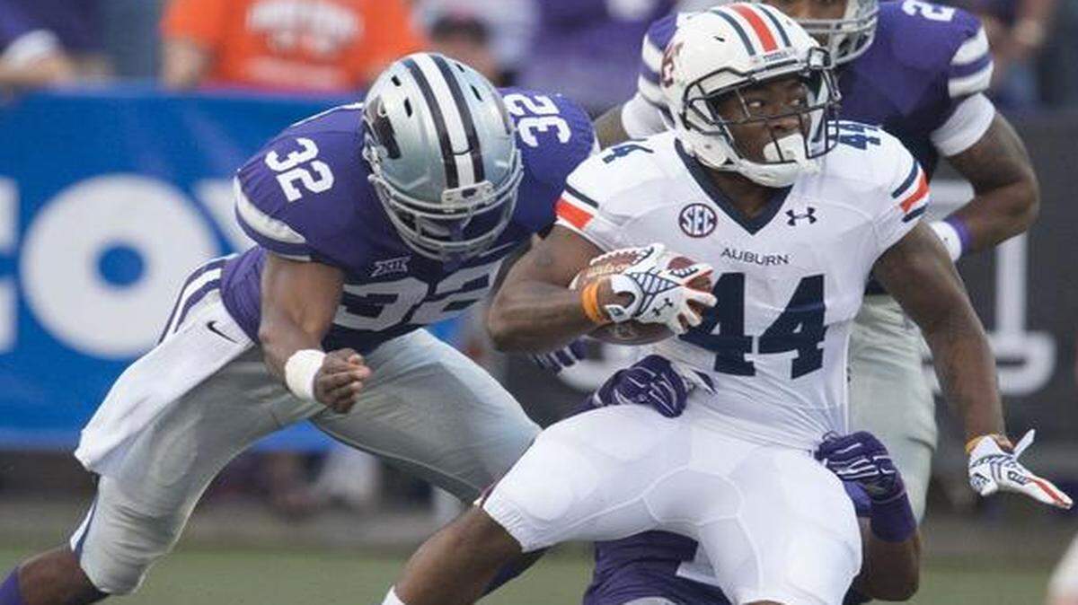
Auburn running back Cameron Artis-Payne tried to get away from Kansas State linebacker Dakorey Johnson (left) during last Thursday’s game.
