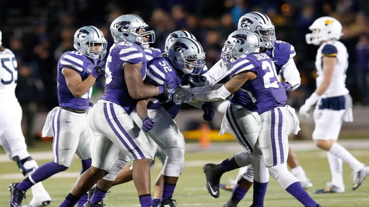 Kansas State defenders celebrate with linebacker Charmeachealle Moore (52) after a sack last season.