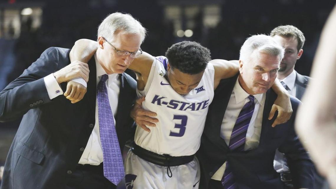 Kansas State’s Kamau Stokes was helped from the court by coach Bruce Weber (right) after injuring his knee against Mississippi at Bramlage Coliseum in Manhattan, Kan., on Saturday.