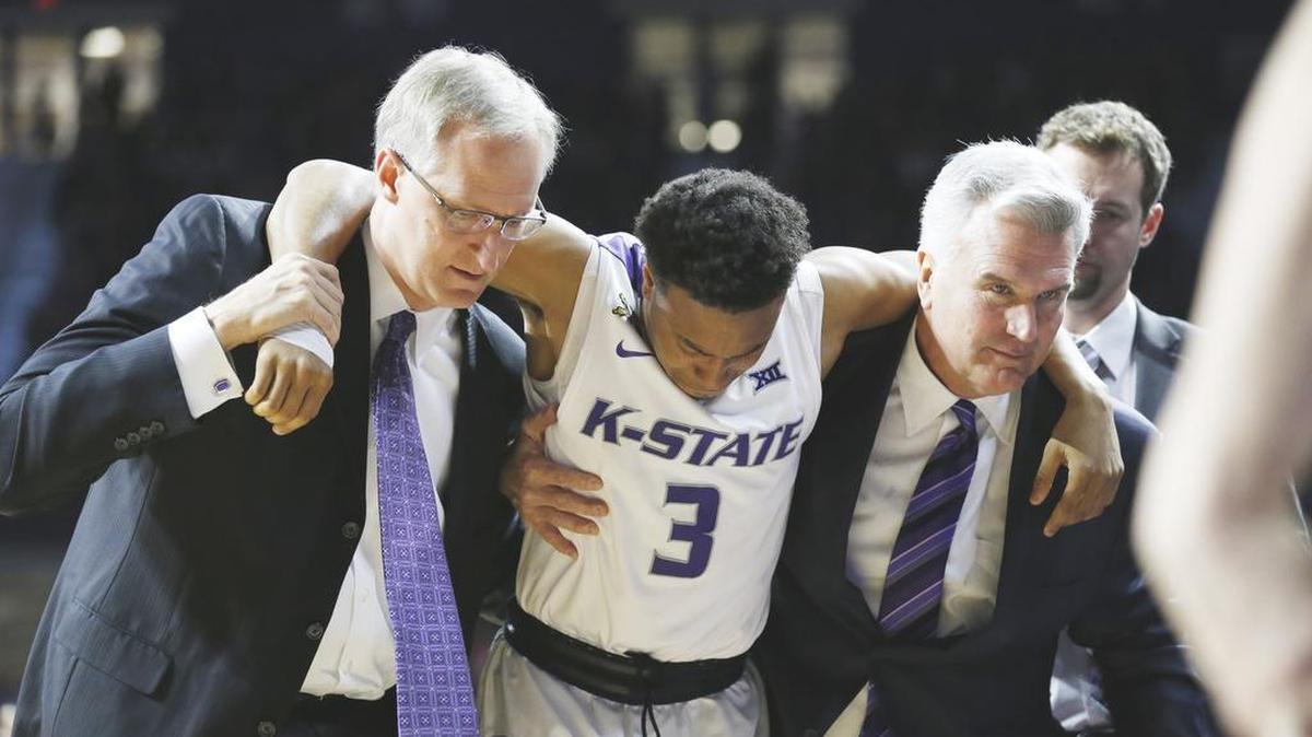 Kansas State guard Kamau Stokes (3) is helped from the court by head coach Bruce Weber, right, after injuring his knee during an NCAA college basketball game against Mississippi in Manhattan, Kan., Saturday, Jan. 30, 2016.