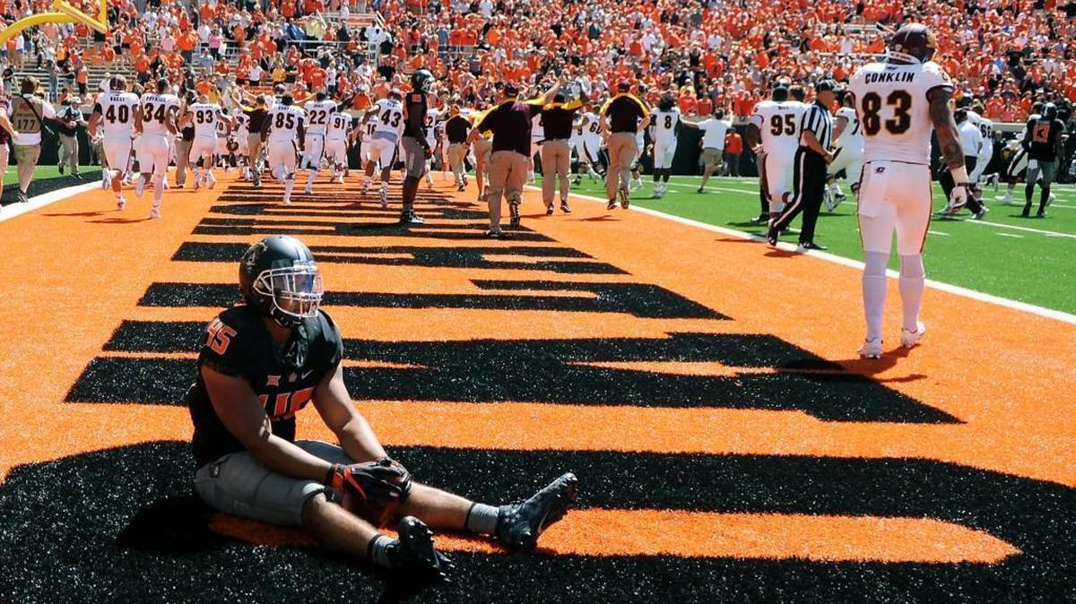 Oklahoma State linebacker Chad Whitener sits alone in the end zone while the Central Michigan team celebrates its 30-27 victory in Stillwater, Okla., on Saturday.