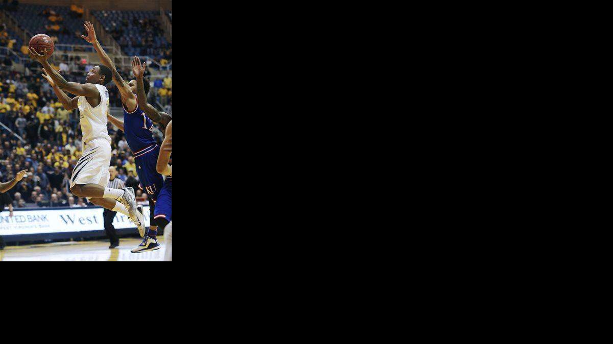 
West Virginia guard Juwan Staten (3) drives past Kansas guard Kelly Oubre Jr. (12) to score the game winning basket in the final seconds of an NCAA college basketball game, Monday, Feb. 16, 2015, in Morgantown, W.Va. West Virginia defeated Kansas 62-61. (AP Photo/Raymond Thompson)
