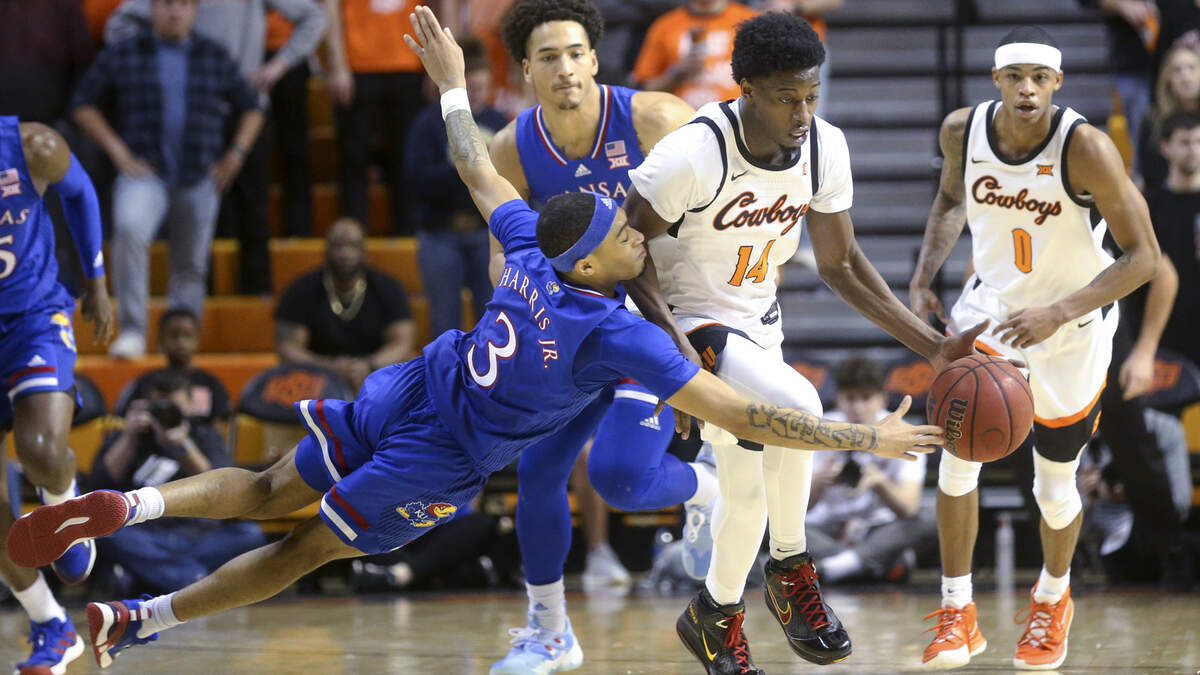 Kansas guard Dajuan Harris Jr. (3) attempts to steal the ball from Oklahoma State guard Bryce Williams (14) during a game in Stillwater, Okla., Tuesday, Jan. 4, 2022.