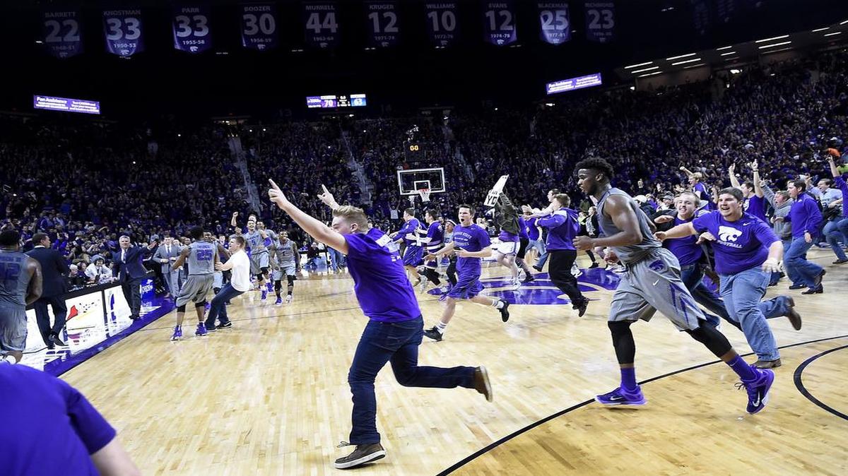 As students pour onto the court, Kansas coach Bill Self (far left) approaches KSU coach Bruce Weber to shake hands after Monday night's game at Bramlage Coliseum.