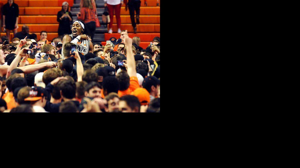 Oklahoma State center Anthony Allen Jr., center, celebrates with fans following the 67-62 win over Kansas in an NCAA basketball game in Stillwater, Okla., Saturday, Feb. 7, 2015.