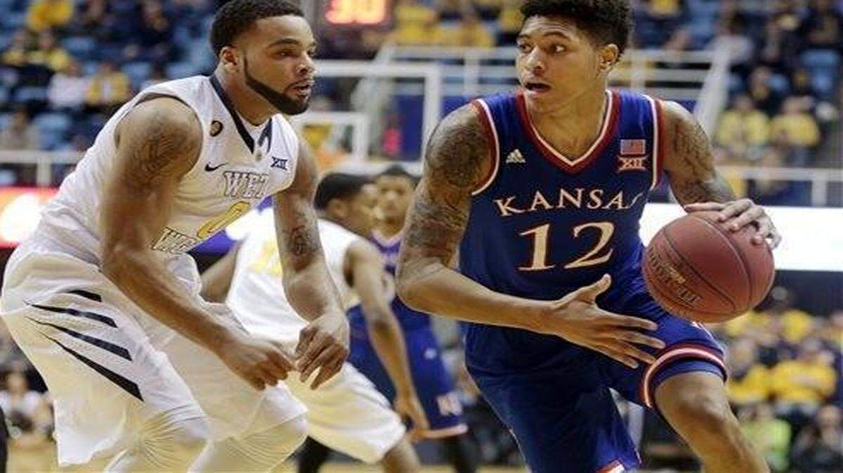 
Kansas guard Kelly Oubre Jr. (12) looks to pass while being defended by West Virginia guard Jaysean Paige during Monday’s game in Morgantown.
