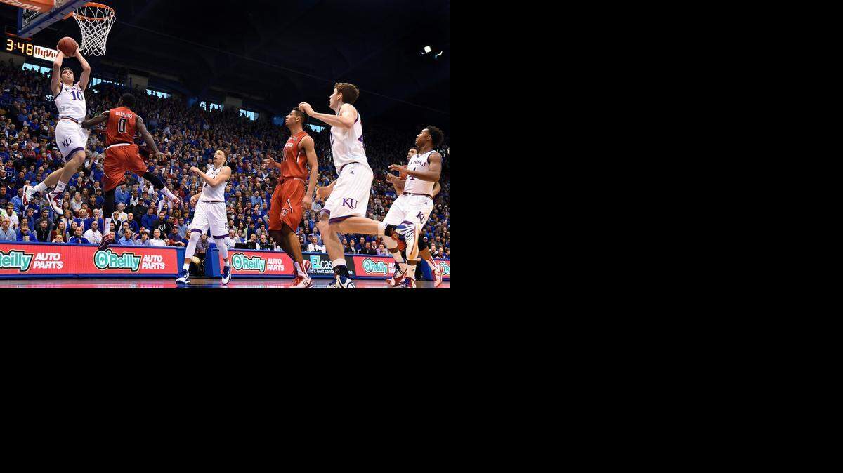 
Svi Mykhailiuk (left) scored two of his five points Saturday afternoon on a layup over Texas Tech’s Devaugntah Williams.


