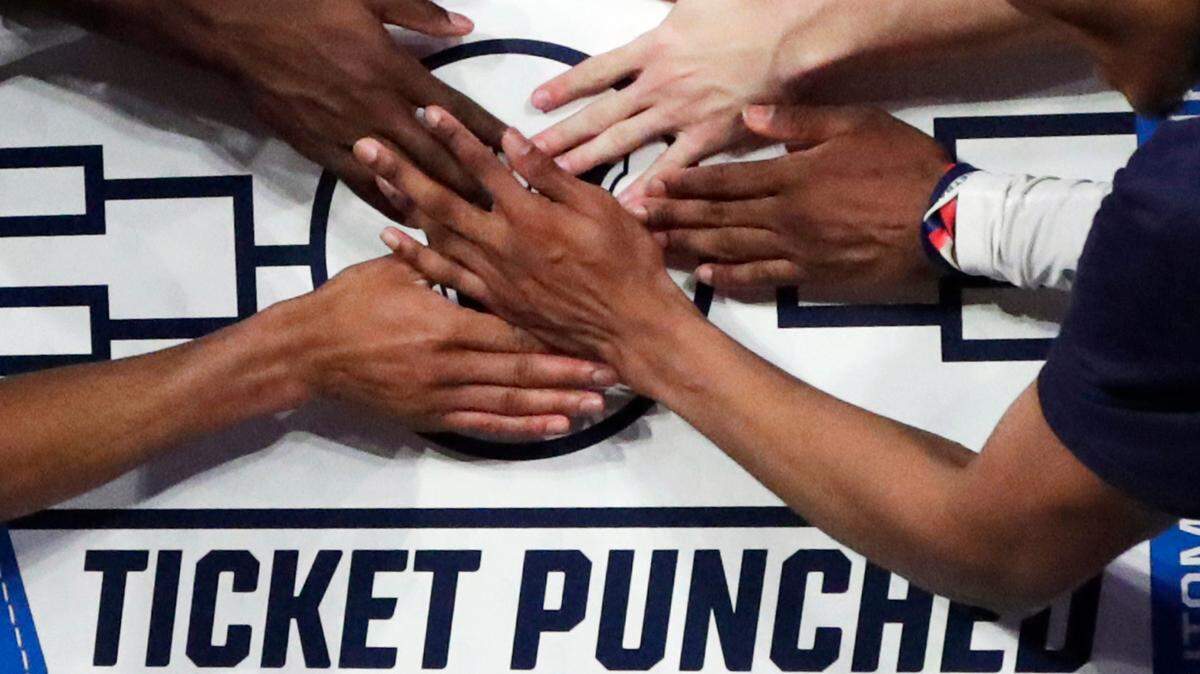 In this March 16, 2019, file photo, Villanova players stick a logo of their team on a bracket board after defeating Seton Hall 74-72 in an NCAA college basketball game in the championship of the Big East Conference tournament in New York.