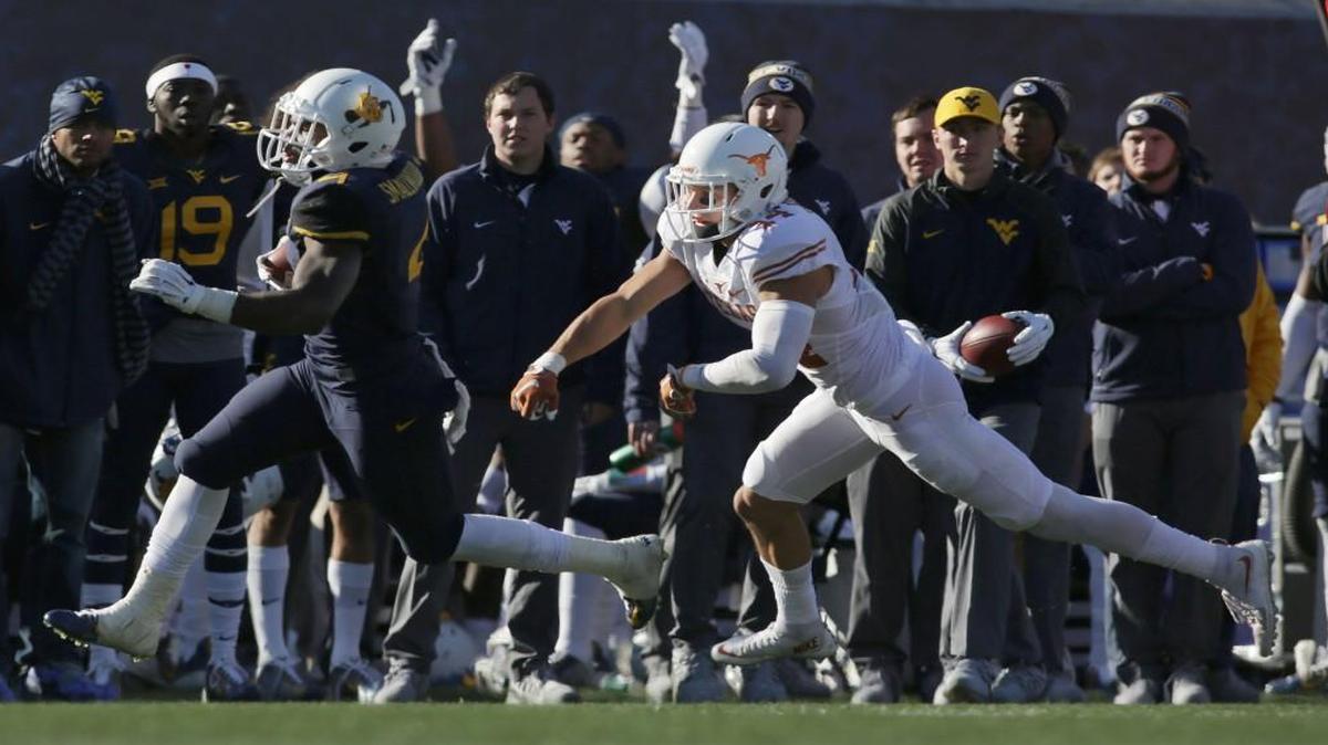 West Virginia running back Wendell Smallwood (left) ran away from Texas safety Dylan Haines during last Saturday’s game.