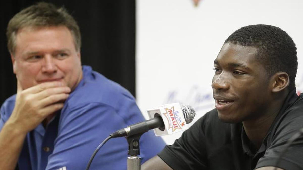 Cheick Diallo speaks with reporters while Kansas coach Bill Self listens during a news conference after Kansas defeated Vanderbilt 70-63 in an NCAA college basketball game in the Maui Invitational on Wednesday, Nov. 25, 2015, in Lahaina, Hawaii. The NCAA will allow Diallo to begin playing for No. 5 Kansas beginning next week, ending a months-long investigation into the prospect's education and background. (AP Photo/Rick Bowmer)