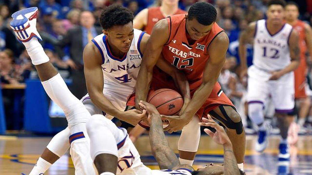
KU teammates Devonte’ Graham (left) and Jamari Traylor (bottom) put the squeeze on Texas Tech’s Keenan Evans in the first half Saturday at Allen Fieldhouse in Lawrence. Kansas won the game 86-54 to improve to 13-2 overall and 2-0 in the Big 12.
