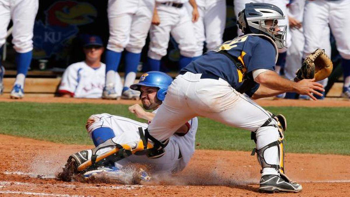 
Kansas' Dakota Smith, left, slides safely past West Virginia catcher Cameron O'Brien, right in the fifth inning of a first-round game in the Big 12 Baseball Championship tournament in Oklahoma City, Wednesday, May 21, 2014. Smith was safe on the play on a double hit by Tucker Tharp.
